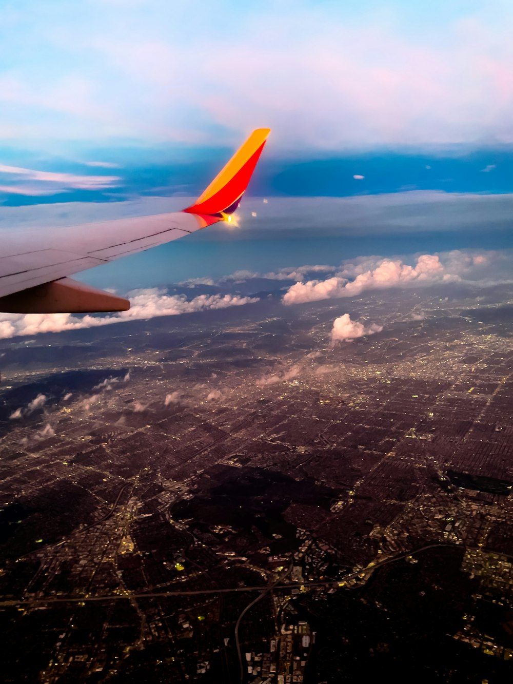 the wing of an airplane flying over a city