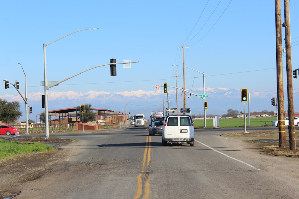 a white van driving down a street next to a traffic light