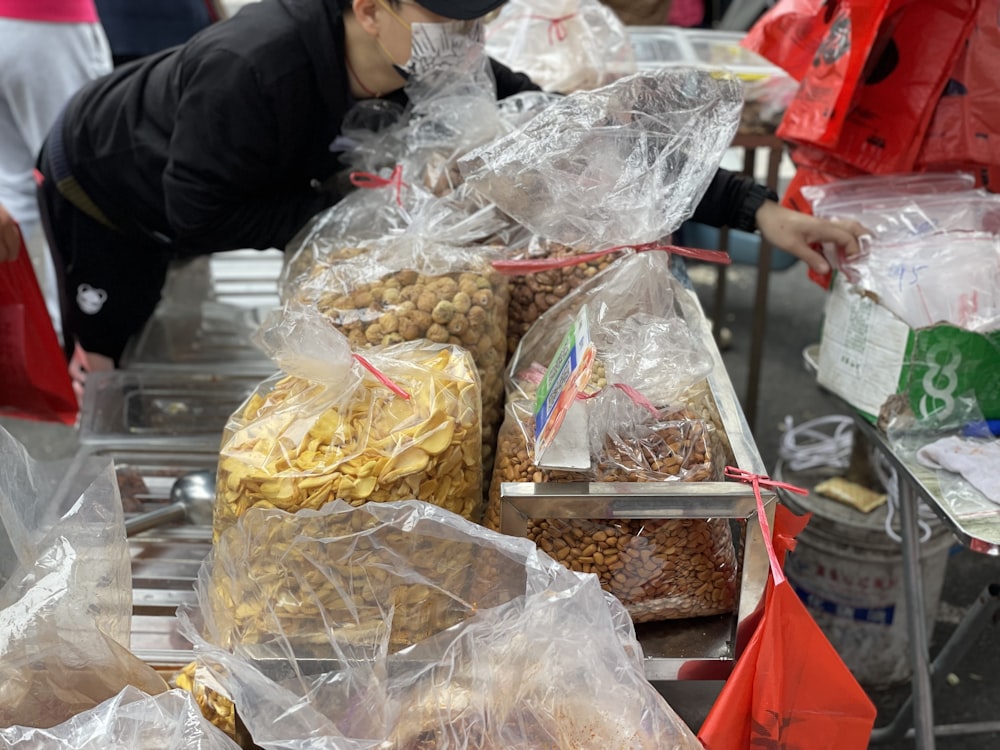 a man standing next to a table filled with bags of food