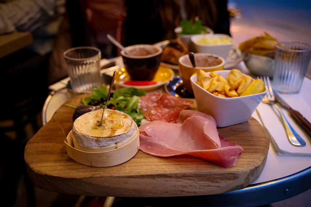 a wooden table topped with bowls of food