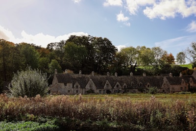 a large house with a lot of windows in the middle of a field