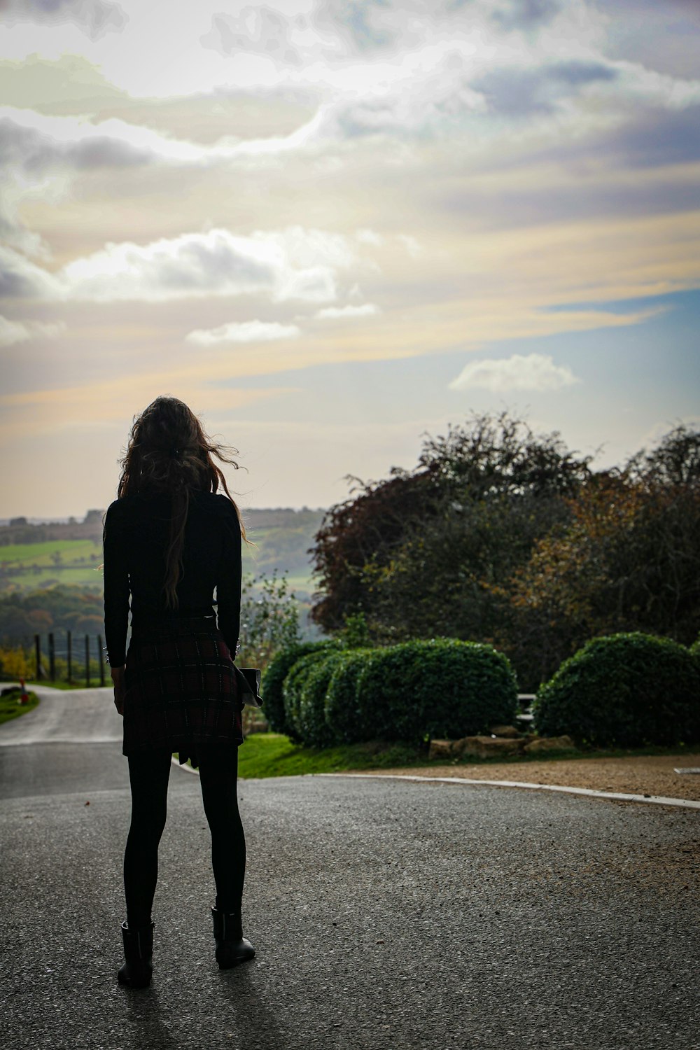 a woman standing in the middle of a road