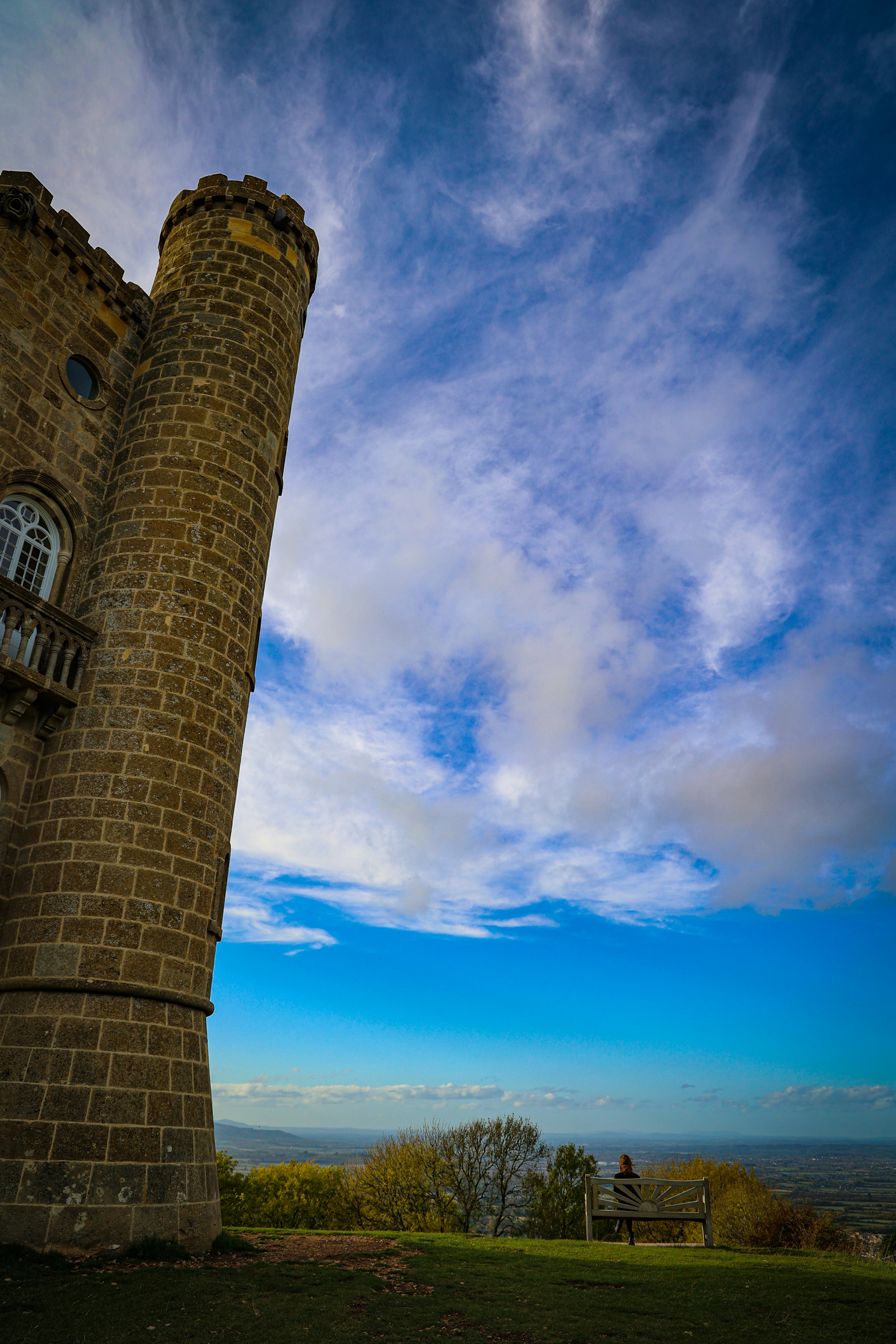 uma torre de tijolos alta sentada no topo de um campo verde exuberante