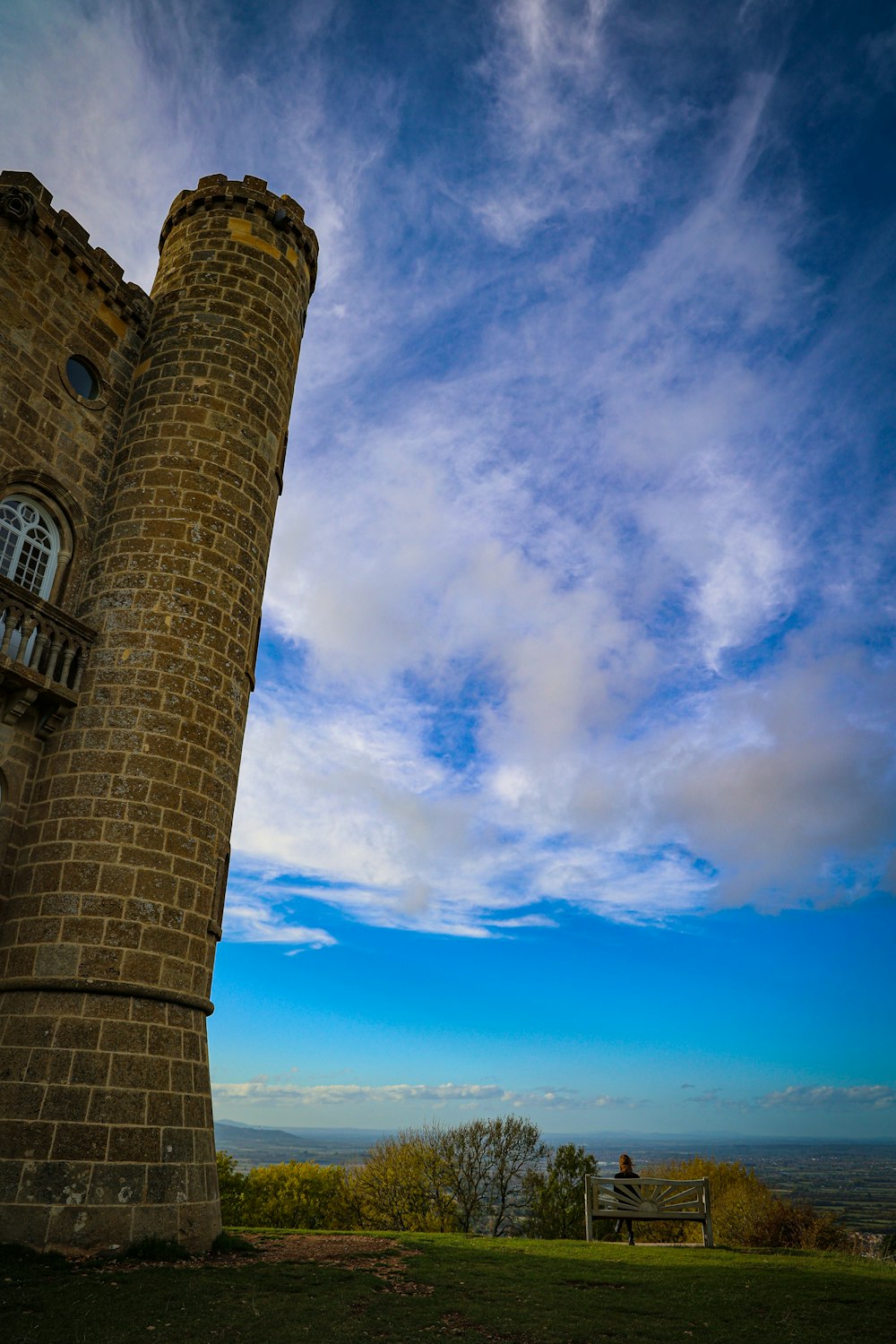 a tall brick tower sitting on top of a lush green field