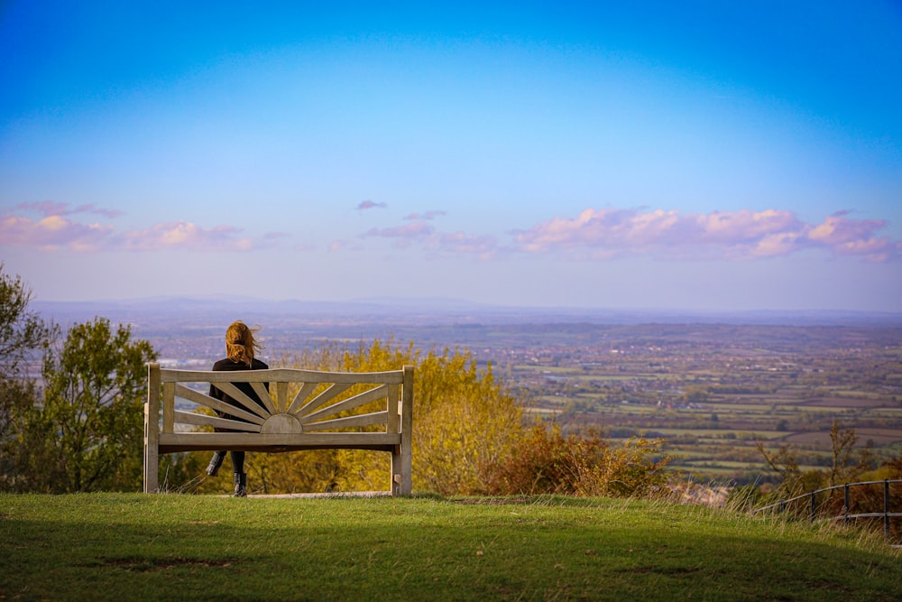 a person sitting on a bench overlooking a valley