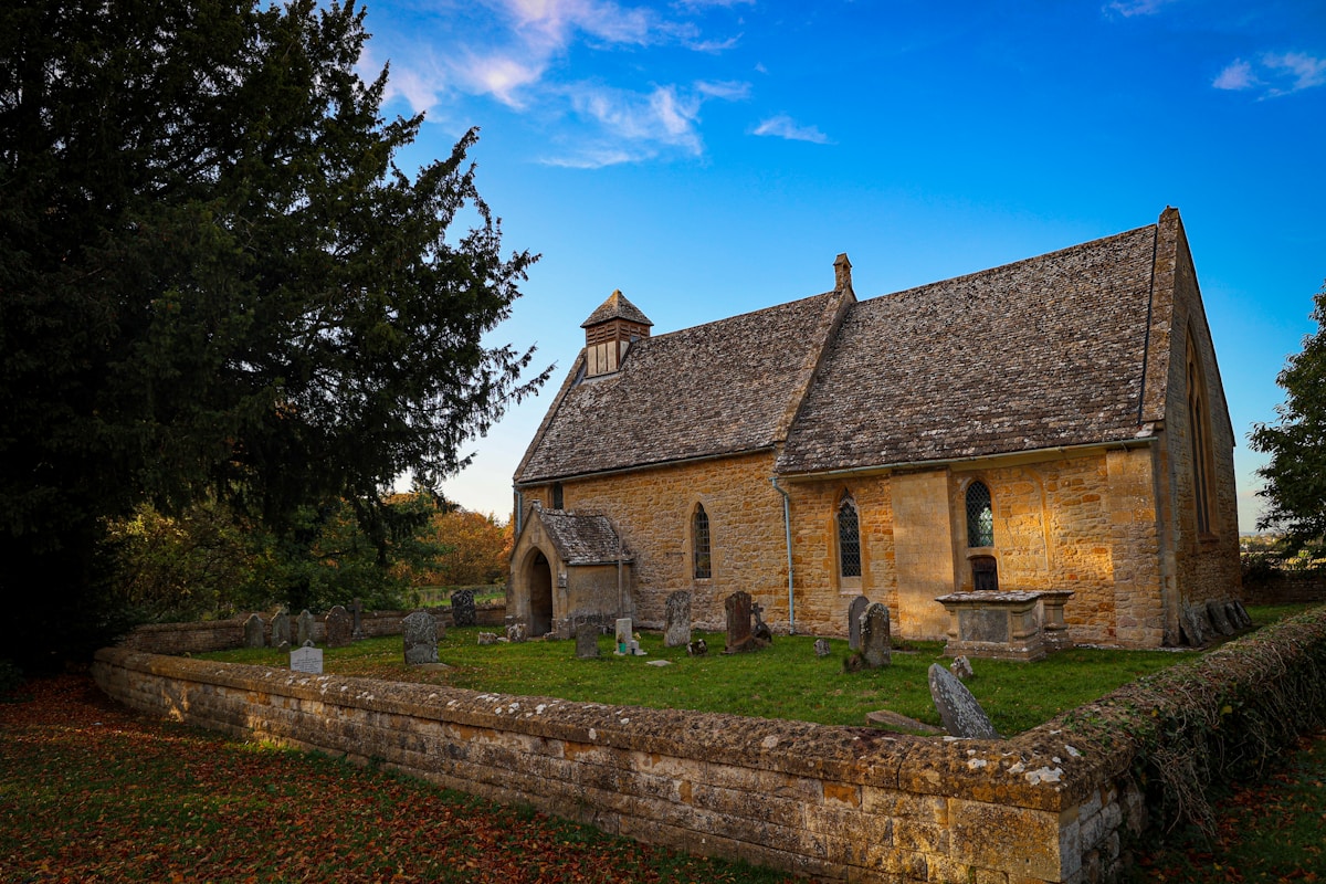 a stone church with a steeple and a stone wall