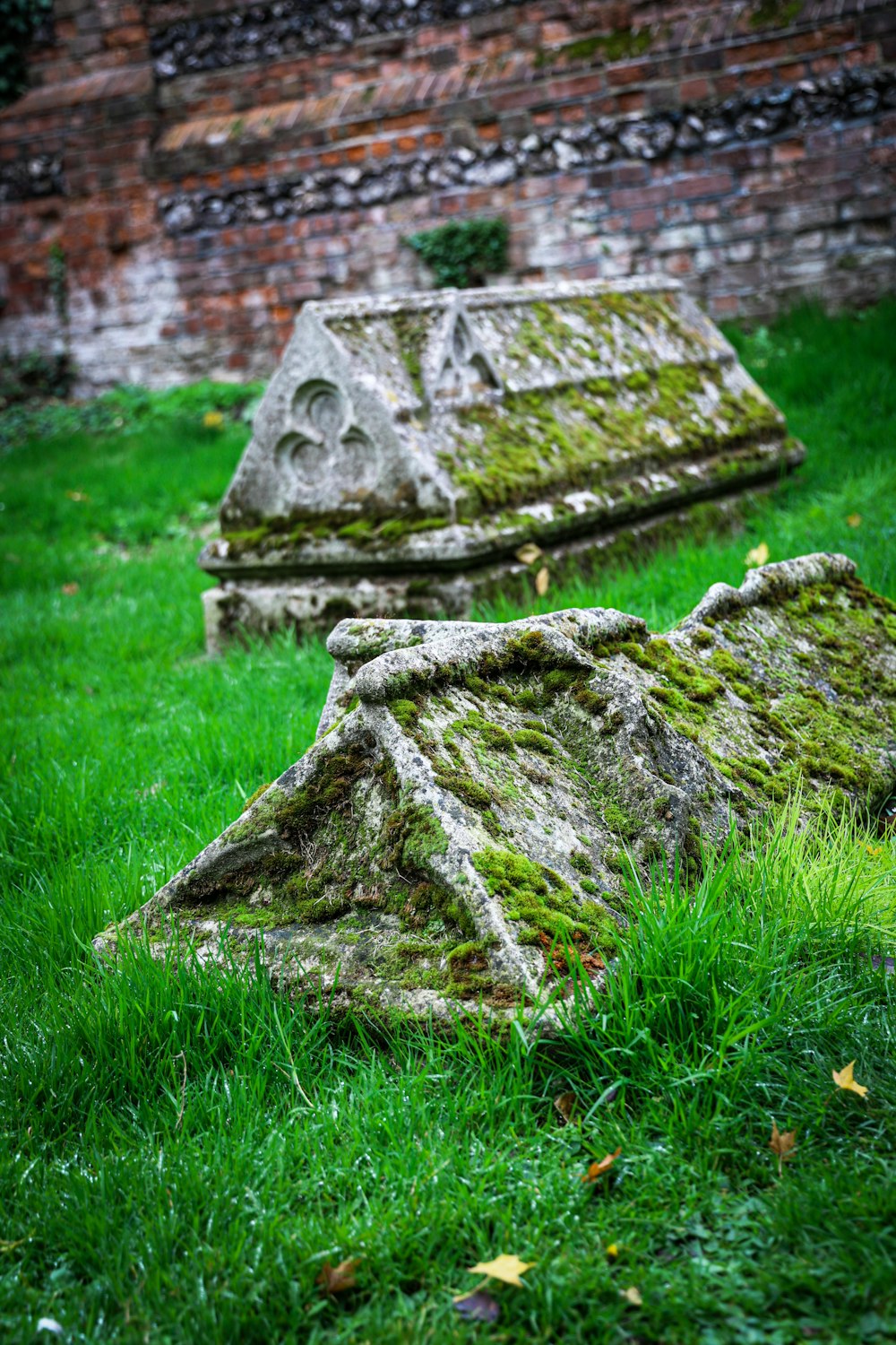 a couple of stone headstones sitting in the grass