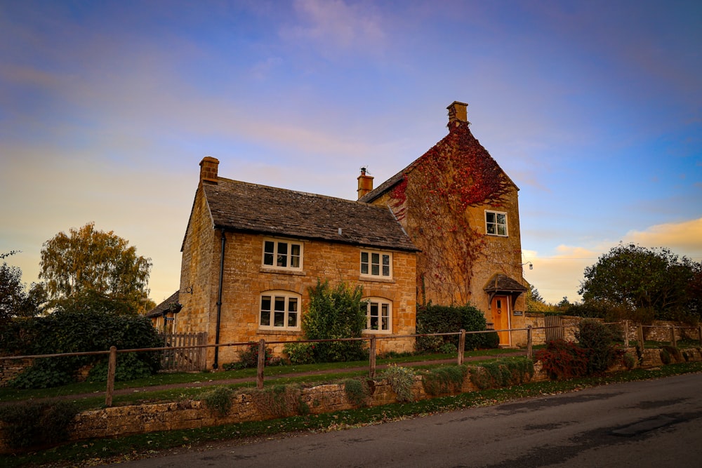 a large brick house with a fence in front of it