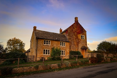 a large brick house with a fence in front of it