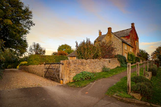 a stone house with a stone fence and gate