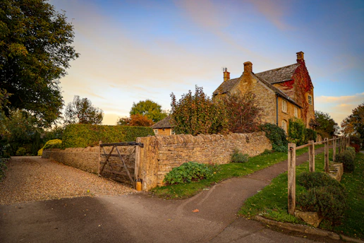 a stone house with a stone fence and gate