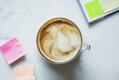 A close-up of personalized coaching notes beside a cup of coffee.