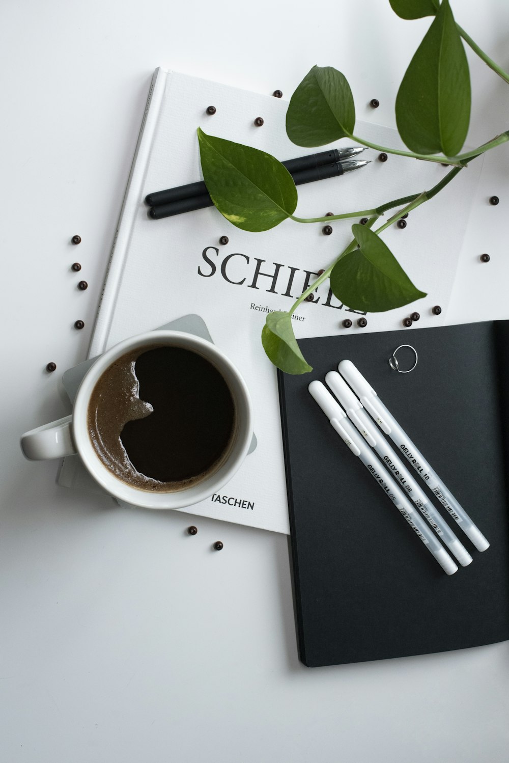 Eine Tasse Kaffee neben Notizbuch und Stift