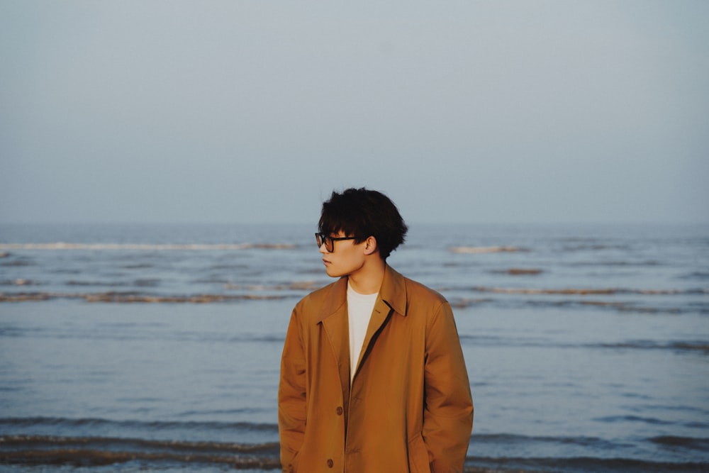 a man standing on a beach next to the ocean