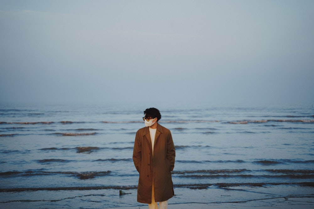 a man standing on a beach next to the ocean