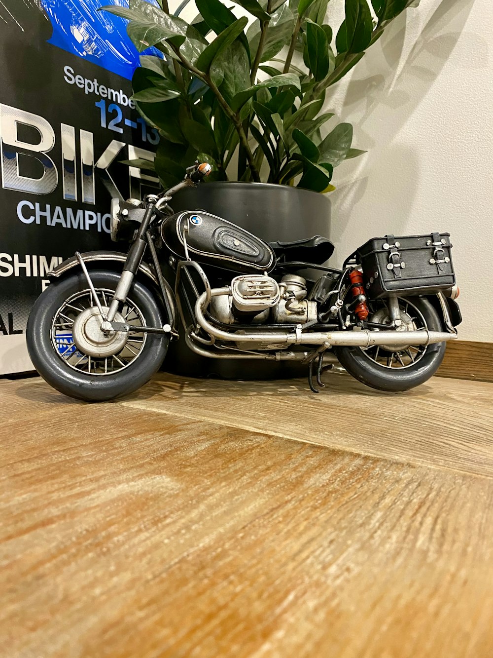 a black motorcycle parked on top of a wooden floor