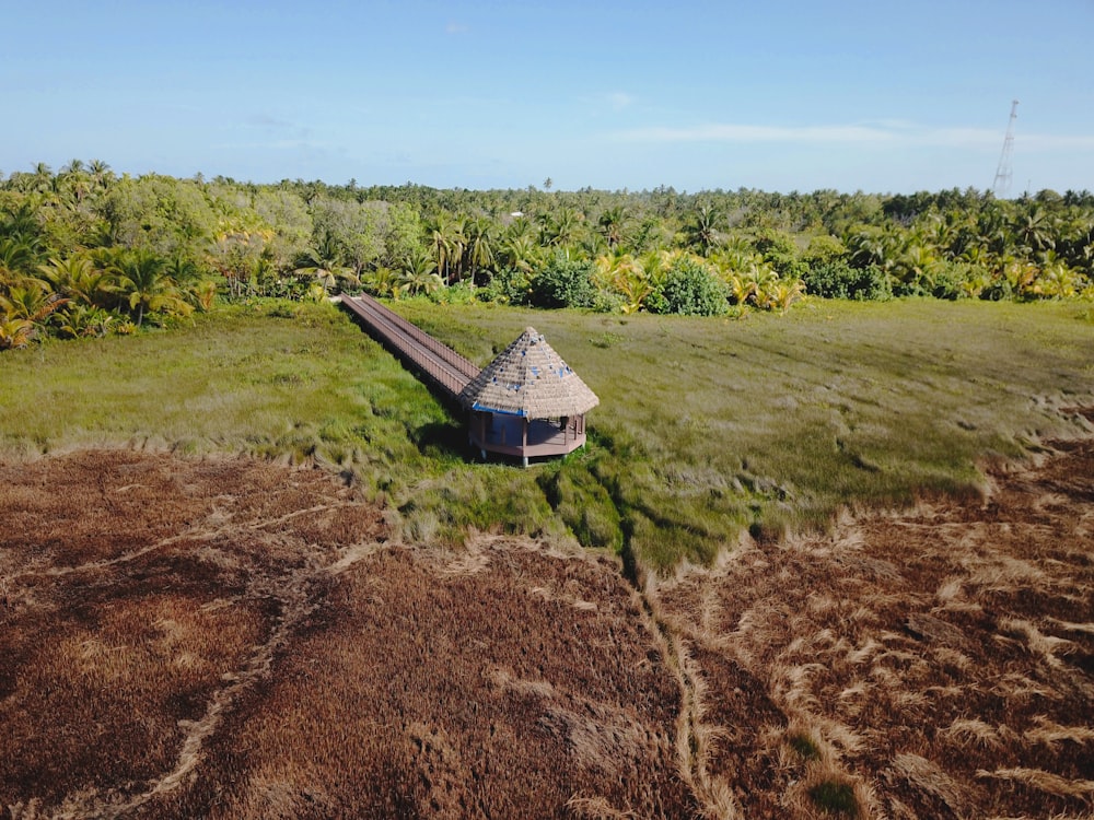 an aerial view of a small hut in the middle of a field