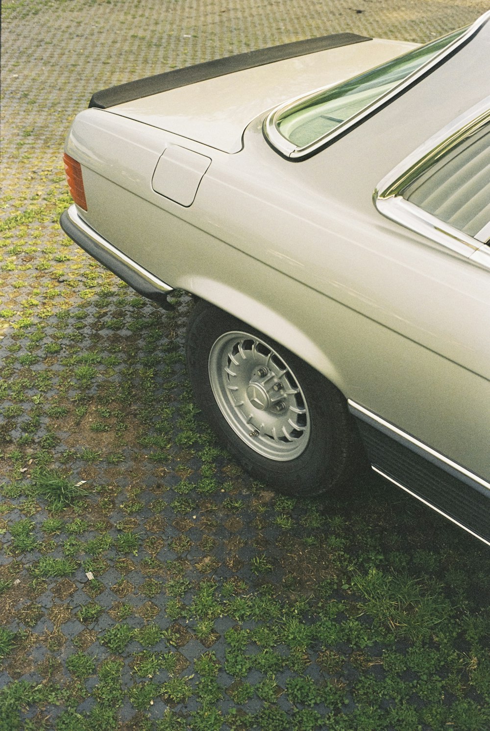 a white car parked on top of a grass covered field