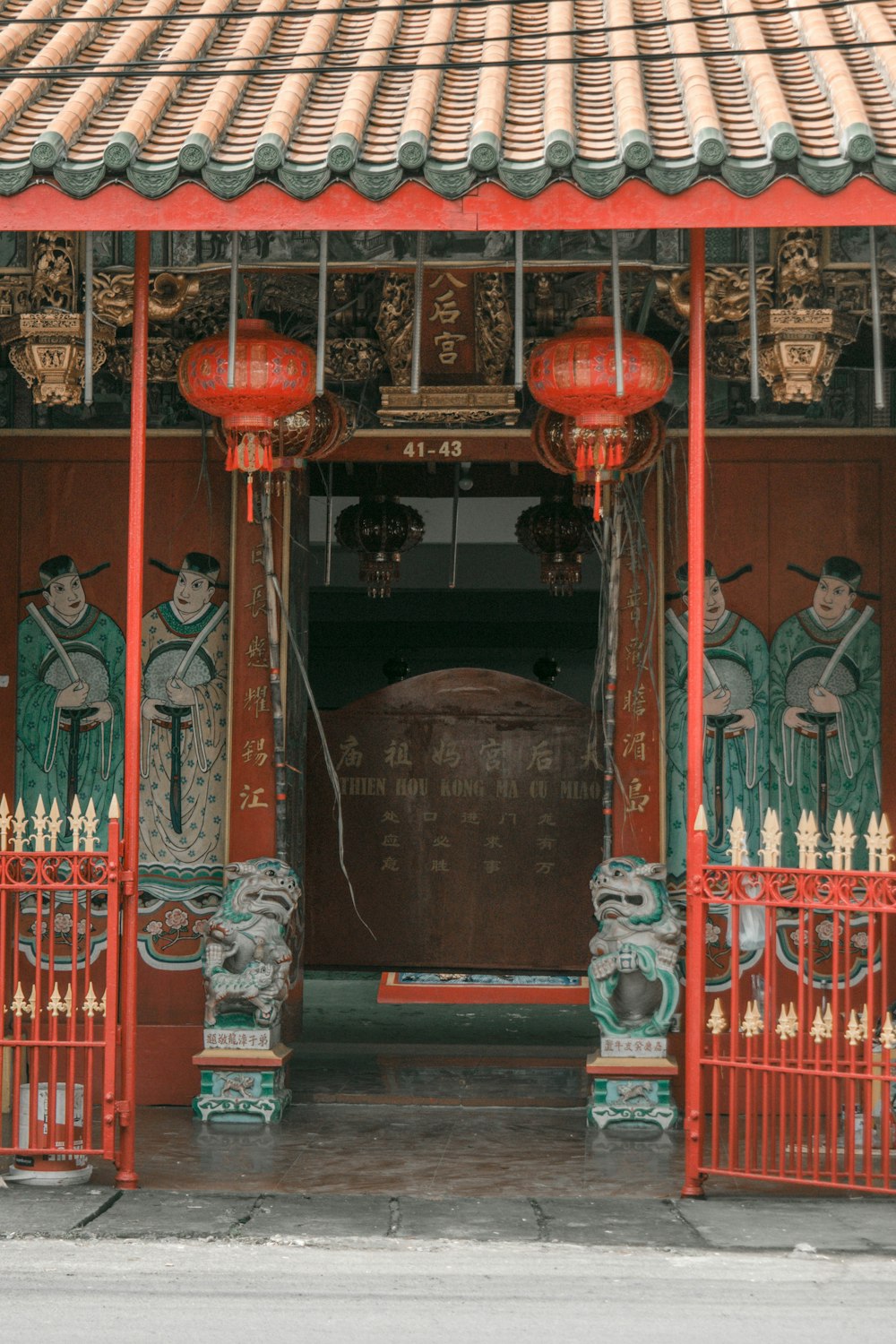 a red and green building with a red gate