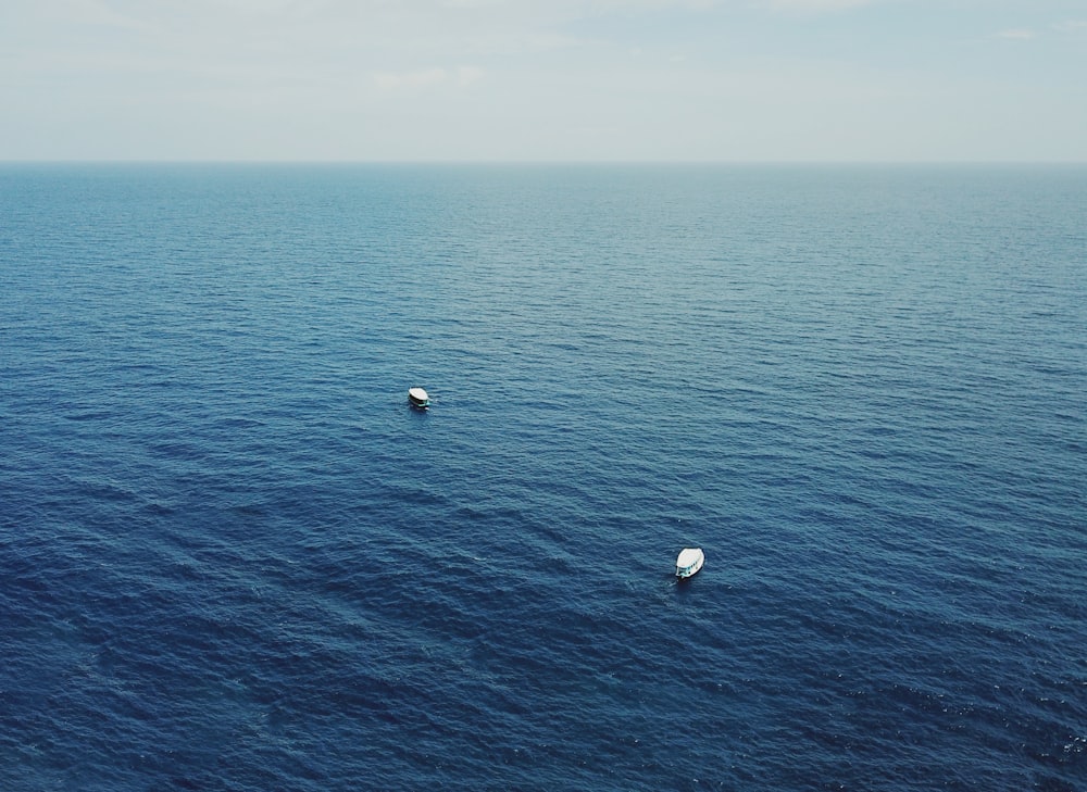 a couple of boats floating on top of a large body of water