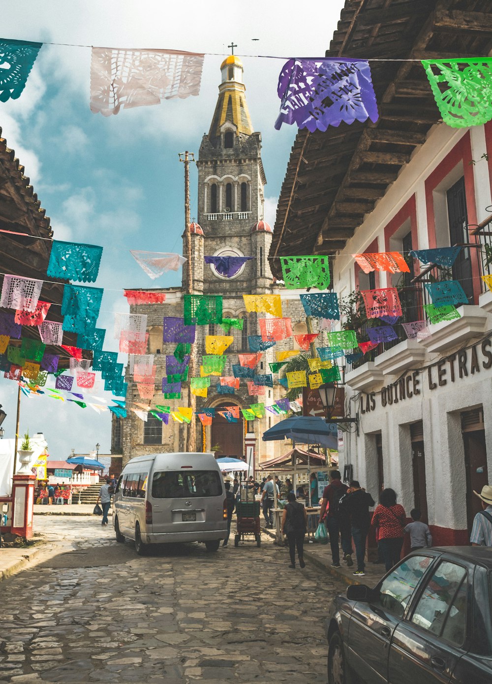 Un grupo de personas caminando por una calle empedrada