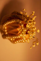 Close-up of a handcrafted, ivory and champagne toned decorative piece with intricate details.