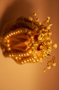 Close-up of delicate resin decorative pieces with golden shimmer, elegantly arranged on a creamy textured background.