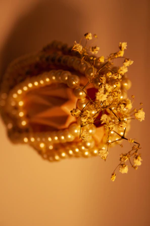 Close-up of a handcrafted, ivory and champagne toned decorative piece with intricate details.