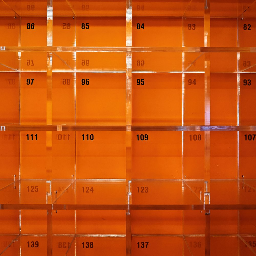 a number of orange shelves with numbers on them