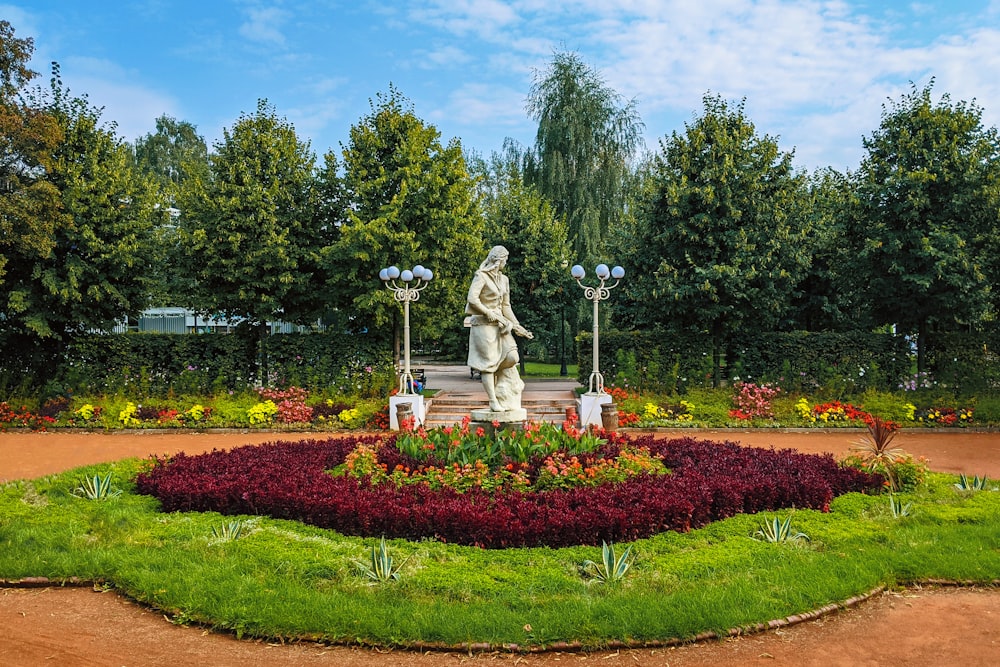 a statue of a man in a flower garden