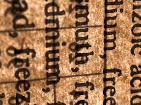 A close-up view of text on paper, highlighting several words in a serif font. The image focuses on the texture of the paper and the details of the printed text.