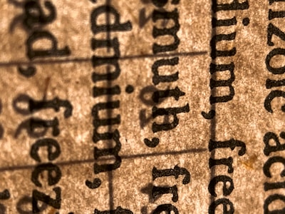 A close-up view of text on paper, highlighting several words in a serif font. The image focuses on the texture of the paper and the details of the printed text.