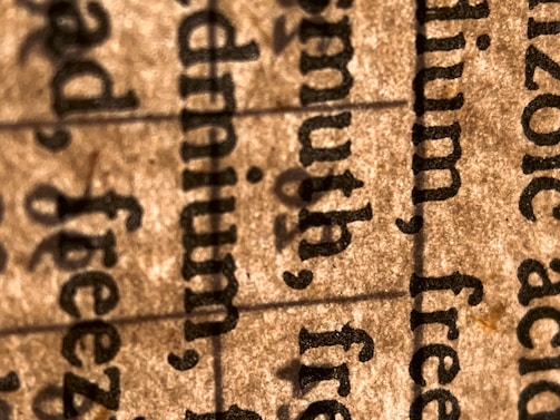 A close-up view of text on paper, highlighting several words in a serif font. The image focuses on the texture of the paper and the details of the printed text.