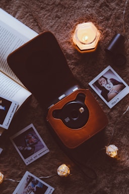 A softly lit photo of a camera resting on a wooden table beside a notebook and pen, inviting connection.