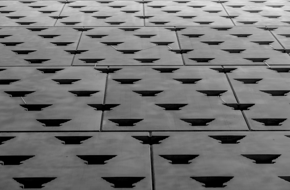 a black and white photo of a wall made of tiles