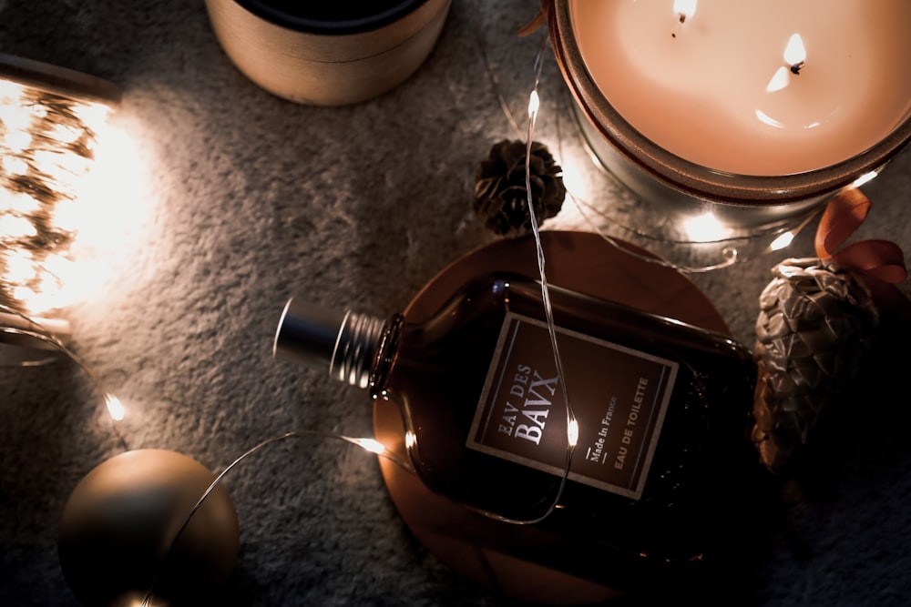 a bottle of wine sitting on top of a table next to a candle