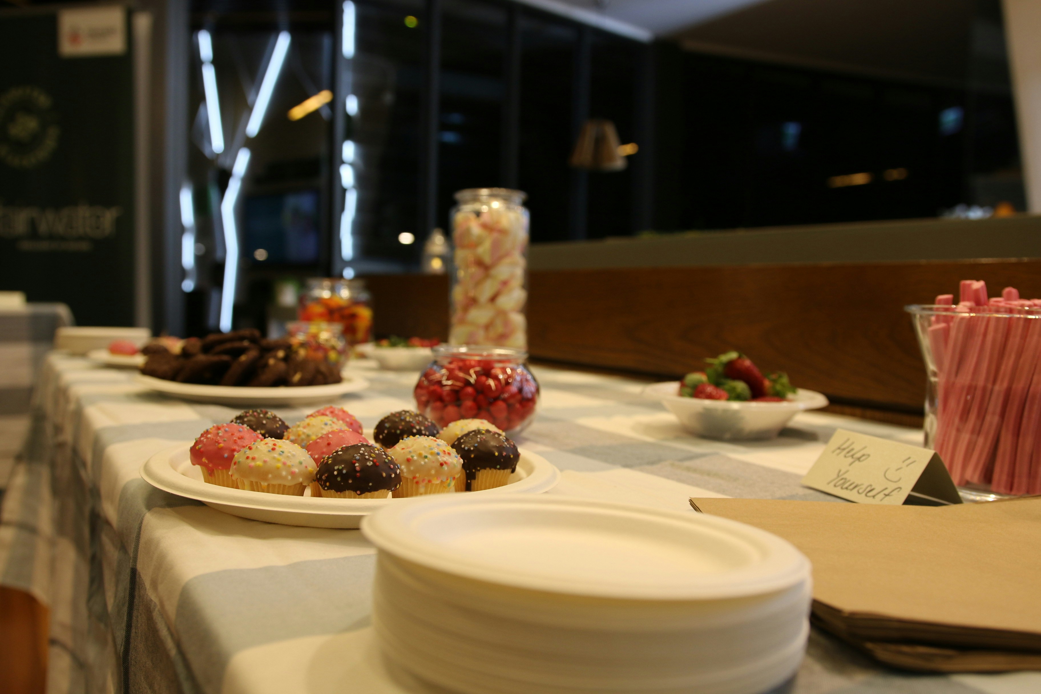 a table topped with plates of desserts and candy