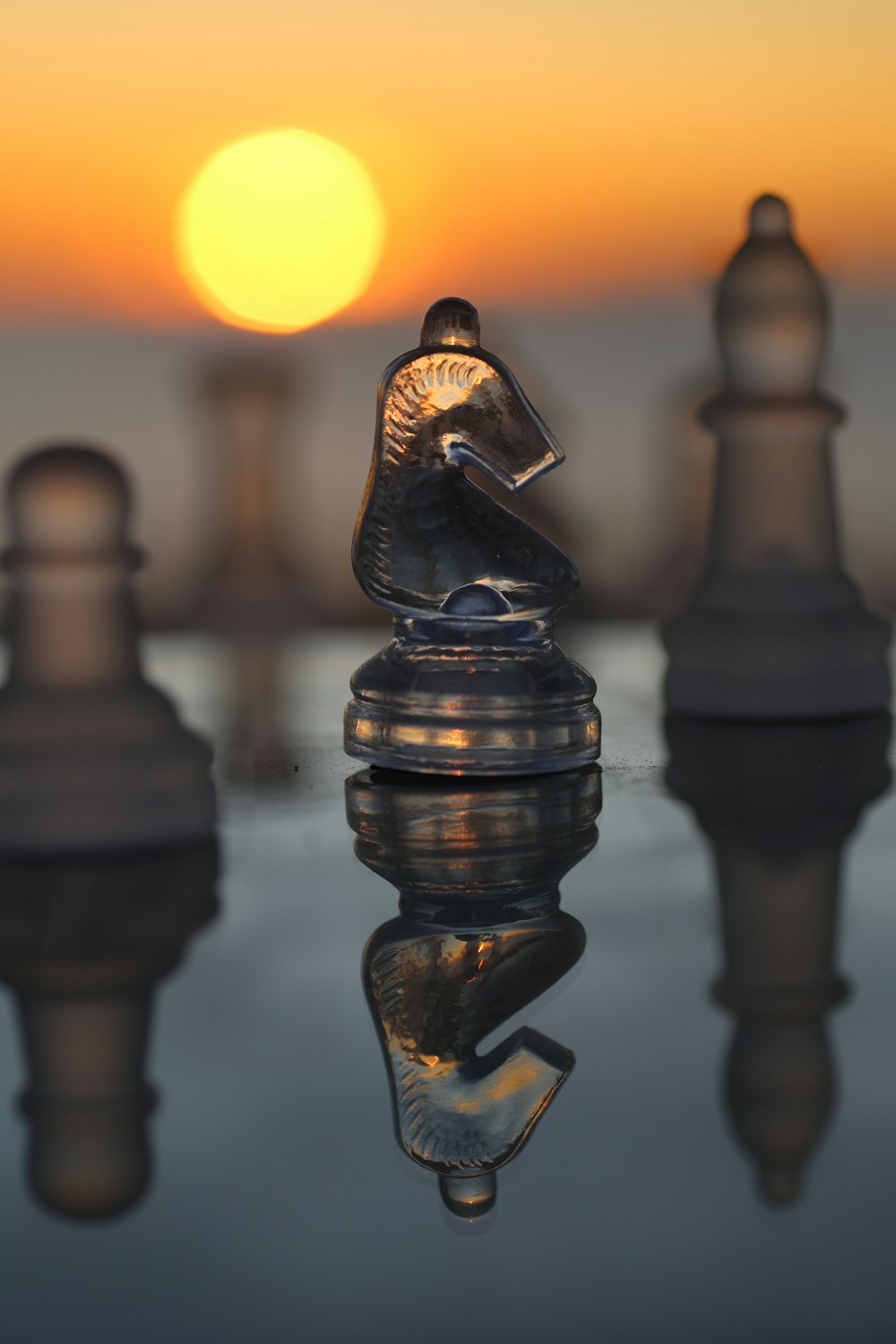 a close up of a chess board with the sun in the background