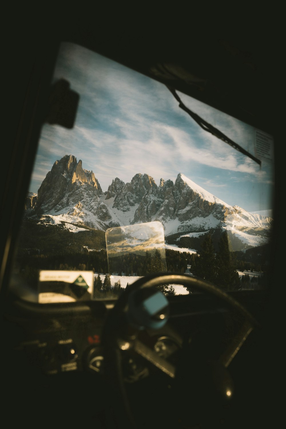 a view of a mountain range from inside a vehicle