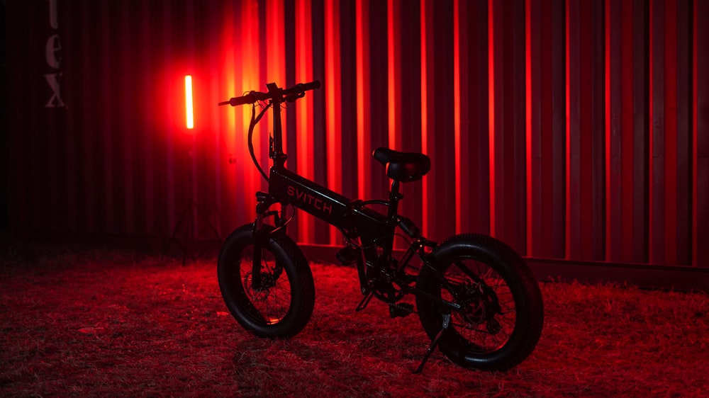 a black bike parked in front of a red wall