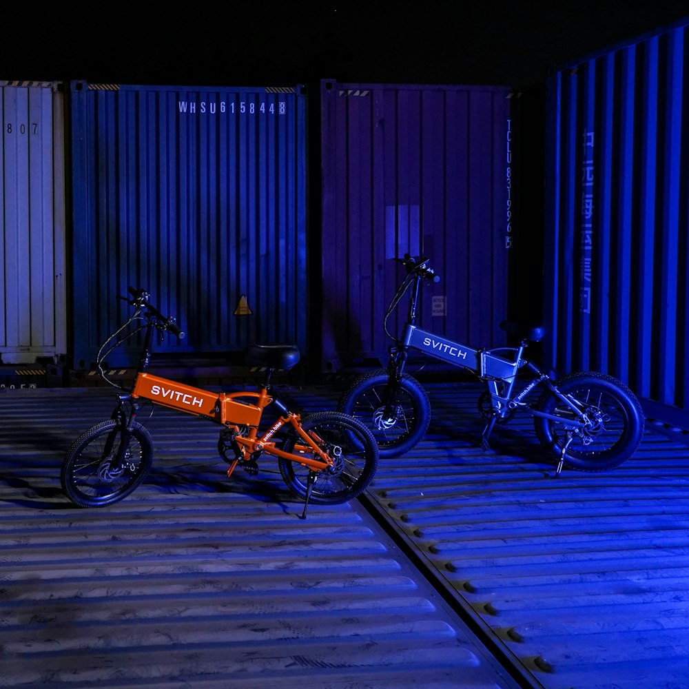 two bikes parked next to each other in front of shipping containers
