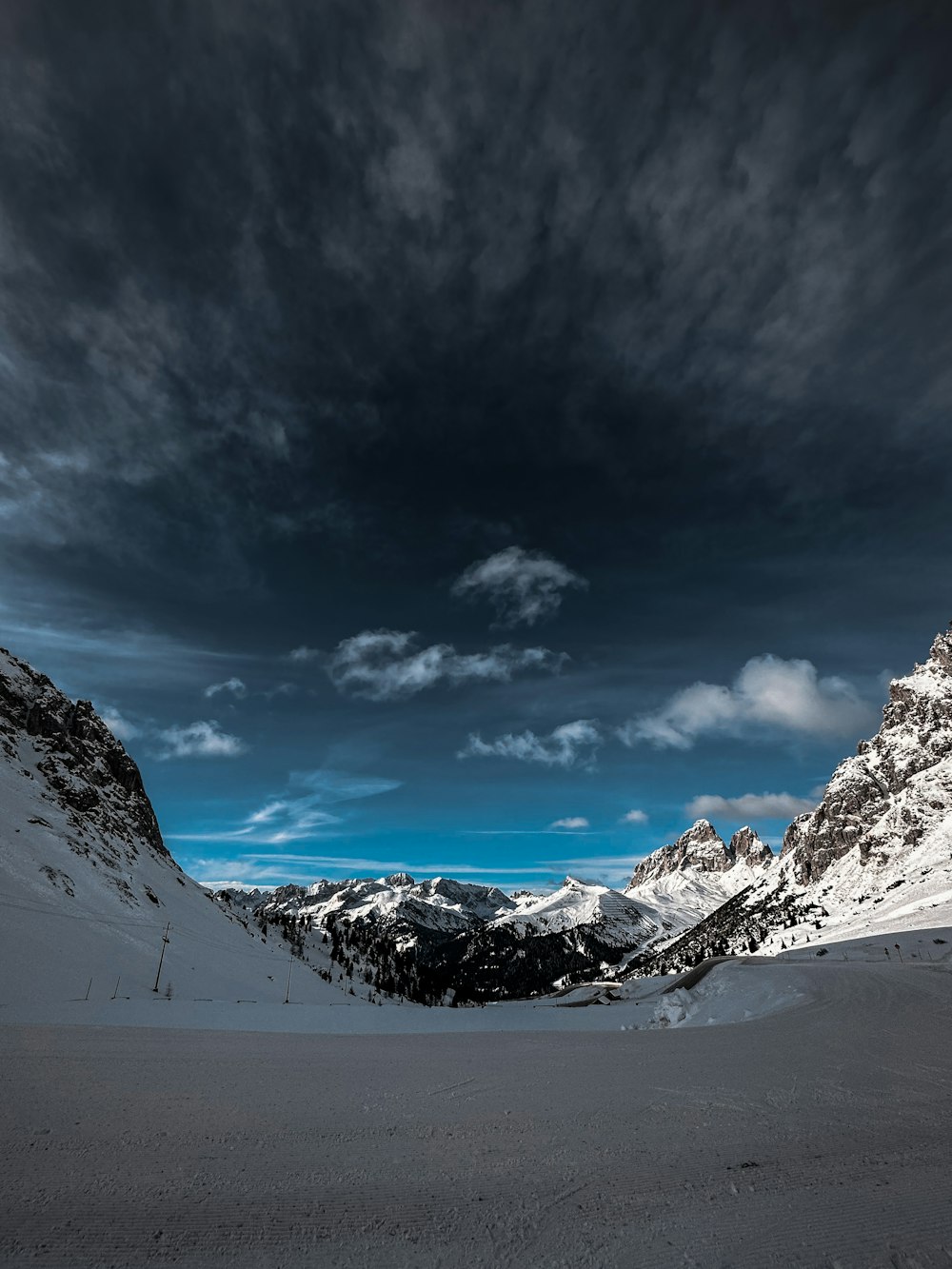 a snow covered mountain range under a cloudy sky