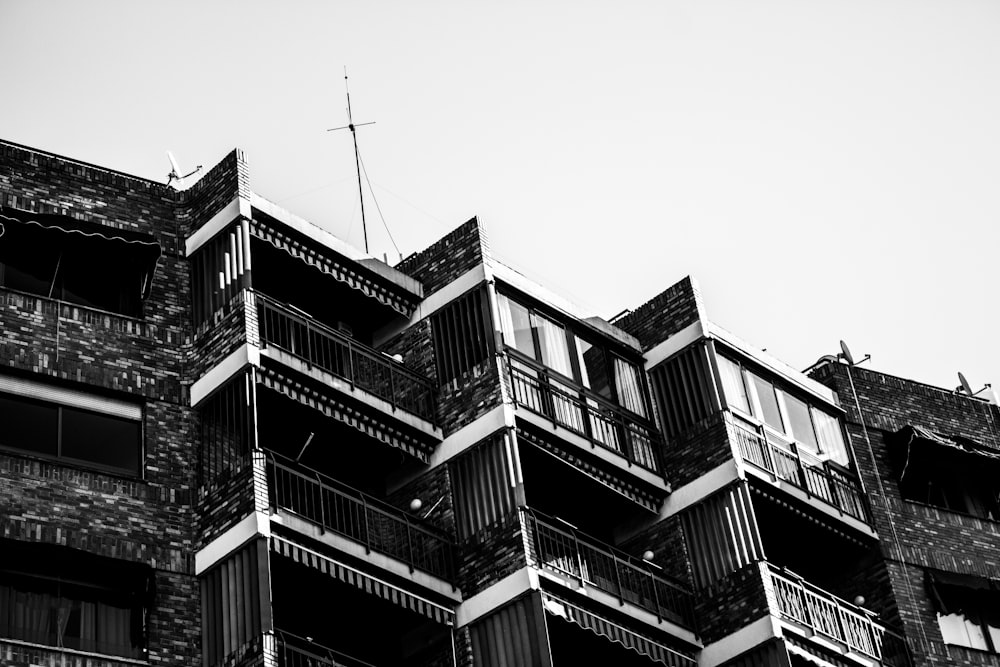 ein Schwarz-Weiß-Foto eines Gebäudes mit Balkon