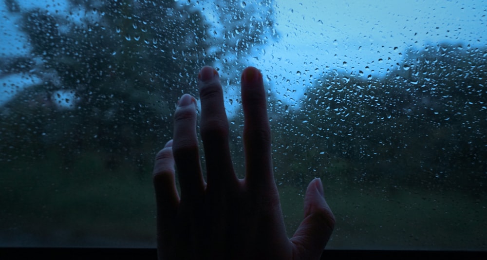 a person is holding their hand out of a window