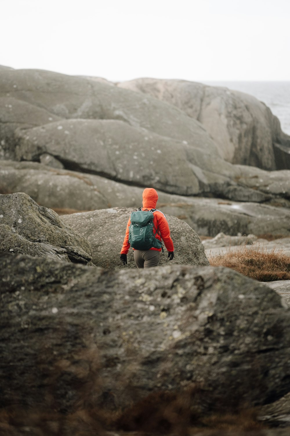 a person with a backpack walking on some rocks