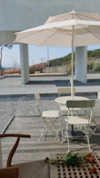 A minimalist white shade sail stretched over a lush garden seating area