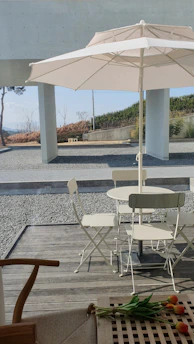 A minimalist white shade sail stretched over a lush garden seating area