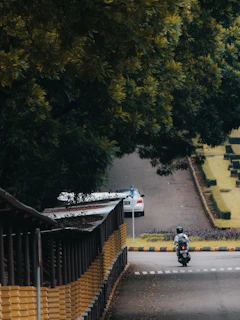 An instructor gently guiding a learner through a quiet neighborhood street, with African cultural art visible in the background.