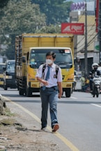 a man wearing a face mask walking down a street
