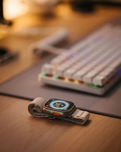 Close-up of a sleek smartwatch glowing softly on a wooden desk.